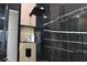 Modern shower with black marble accent wall, rain shower head, and recessed shelving for toiletries at 13413 Hopkinton Ct, Windermere, FL 34786