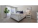 Bright bedroom featuring a large window, a bed with white linen, a lamp, and a potted plant at 1446 Ironbark Bnd, Davenport, FL 33837