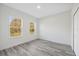 Bedroom with light grey wood floors, white walls, two windows, and a door to closet at 15163 Sw 29Th Terrace Rd, Ocala, FL 34473