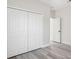 Bright bedroom features wood-look floors, neutral paint, closet doors, and an open doorway at 15163 Sw 29Th Terrace Rd, Ocala, FL 34473