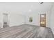 Neutral living room featuring grey wood floors, a large window, and a front door with window panes at 15163 Sw 29Th Terrace Rd, Ocala, FL 34473