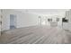 Large living room with gray wood flooring, neutral paint, lots of natural light, and open concept to the kitchen at 15163 Sw 29Th Terrace Rd, Ocala, FL 34473