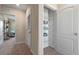 Hallway with laundry and closet featuring wire shelving for organized storage, enhancing functionality and convenience at 1928 Tamarack Pass, Davenport, FL 33837