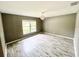 Spacious bedroom featuring wood-look floors and natural light from a large window at 1960 Fawn Meadow Cir, St Cloud, FL 34772