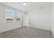 Bright bedroom featuring neutral carpet, two large windows, and an entry door at 2513 Merseyside Ct, Haines City, FL 33844