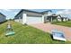 Charming home exterior with a brick driveway, lush green lawn, and a two-car garage at 2513 Merseyside Ct, Haines City, FL 33844