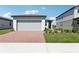 Charming single-story home with a brick driveway, landscaped yard, and attached two-car garage at 2513 Merseyside Ct, Haines City, FL 33844