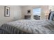 Bedroom with a gray upholstered bed featuring patterned linens, a bright window, and neutral decor at 2634 Angel Falls Dr, Davenport, FL 33837