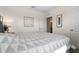 Bedroom featuring a gray upholstered bed with patterned linens, white walls, and neutral decor at 2634 Angel Falls Dr, Davenport, FL 33837