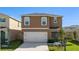 Charming home featuring a two-car garage, blue front door, and a well-manicured lawn at 2634 Angel Falls Dr, Davenport, FL 33837