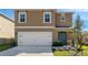 Charming home featuring a two-car garage, blue front door, and a well-manicured lawn at 2634 Angel Falls Dr, Davenport, FL 33837