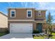 Charming home featuring a two-car garage, blue front door, and a well-manicured lawn at 2634 Angel Falls Dr, Davenport, FL 33837