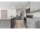 Modern kitchen featuring granite countertops, stainless steel appliances, and a large island with seating at 2634 Angel Falls Dr, Davenport, FL 33837