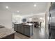 Open-concept kitchen with gray island, granite counters, and stainless steel appliances at 2634 Angel Falls Dr, Davenport, FL 33837