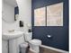 Cozy powder room featuring modern fixtures, artwork, and a sleek vanity at 2688 Gouda Dr, Apopka, FL 32703