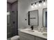 Well-lit bathroom featuring gray tiling in the shower and double sinks at 2693 Sw 153Rd Place Rd, Ocala, FL 34473