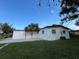 This home boasts a fresh white exterior, complemented by well-maintained green grass and a bright blue sky overhead at 2818 Geoffrey Dr, Orlando, FL 32826