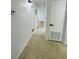 Hallway with neutral tile flooring, updated lighting, and access to multiple rooms at 2818 Geoffrey Dr, Orlando, FL 32826