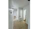 Hallway with neutral tile flooring, updated lighting, and access to multiple rooms at 2818 Geoffrey Dr, Orlando, FL 32826