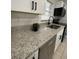 Close-up of granite countertops, stainless steel appliances, and modern black hardware in the updated kitchen at 2818 Geoffrey Dr, Orlando, FL 32826