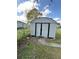 Storage shed in backyard surrounded by grass and a chain link fence at 2818 Geoffrey Dr, Orlando, FL 32826