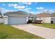 Beautiful one-story home with manicured lawn and a paved driveway leading to a two-car garage at 3733 Pyrite Dr, Orlando, FL 32826