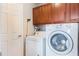 Functional laundry room featuring a washer, dryer, and overhead cabinets at 3733 Pyrite Dr, Orlando, FL 32826