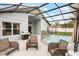 Inviting screened-in pool area featuring comfortable wicker furniture and a modern outdoor grill at 3733 Pyrite Dr, Orlando, FL 32826