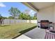 Spacious backyard with a well-maintained lawn, a privacy fence, and a covered patio with a grill at 3771 Whitetail Ct, St Cloud, FL 34772