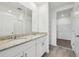 Bathroom featuring dual sinks with a granite countertop and a door to a walk-in closet at 4002 Copperleaf Ln, Poinciana, FL 34759