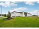 Exterior view of home with a well-maintained lawn and lush landscaping at 4002 Copperleaf Ln, Poinciana, FL 34759