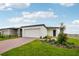 Inviting single-story home featuring a two-car garage, brick driveway, and professionally landscaped front yard at 4002 Copperleaf Ln, Poinciana, FL 34759