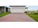 Charming single-story home with a two-car garage, red brick driveway, and well-manicured lawn at 4002 Copperleaf Ln, Poinciana, FL 34759