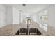Gourmet kitchen island features granite countertops, a stainless steel sink, and a view of the light-filled living area at 4002 Copperleaf Ln, Poinciana, FL 34759