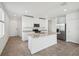 Modern kitchen showcasing a center island with granite countertops, stainless steel appliances, and white cabinetry at 4002 Copperleaf Ln, Poinciana, FL 34759