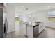 Contemporary kitchen island boasts granite countertops, a stainless steel sink, and views of the bright, open living space at 4002 Copperleaf Ln, Poinciana, FL 34759