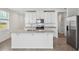 Eat-in kitchen featuring white cabinets, granite countertops, stainless steel appliances, and a central island at 4002 Copperleaf Ln, Poinciana, FL 34759