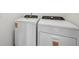 Well-equipped laundry area featuring a modern white washing machine and dryer set at 4002 Copperleaf Ln, Poinciana, FL 34759