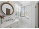 White bathroom featuring a large mirror, marble countertops, and a window bringing in natural light at 401 E Robinson St # 101, Orlando, FL 32801