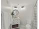 Updated bathroom featuring a circular mirror, decorative lighting, and a shower/tub combo with a gray and white curtain at 401 E Robinson St # 101, Orlando, FL 32801
