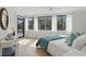 Sun-filled bedroom features a balcony, light wood floors, and a large window with sheer white curtains at 401 E Robinson St # 101, Orlando, FL 32801