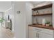 Convenient butler pantry with floating wood shelves, a sink, and views into a bright living space at 401 E Robinson St # 101, Orlando, FL 32801