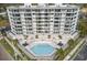 Stunning condo building featuring a pristine pool and jacuzzi surrounded by palm trees and lounge seating at 401 E Robinson St # 101, Orlando, FL 32801