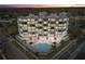 Nighttime aerial view of condo building with a illuminated pool, jacuzzi and well-lit balconies at 401 E Robinson St # 101, Orlando, FL 32801