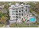 Aerial view of condominium building with balconies, pool and jacuzzi surrounded by manicured landscaping at 401 E Robinson St # 101, Orlando, FL 32801