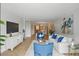 Spacious living area with white sofa, bright blue accent chairs and modern décor flowing into dining area at 401 E Robinson St # 101, Orlando, FL 32801