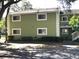 A two-story multi-Gathering building painted green and white with mature trees in the landscape at 4120 Plantation Cove Dr # 301, Orlando, FL 32810