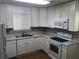A well-lit kitchen with white cabinets and appliances, complete with mosaic tile backsplash at 4120 Plantation Cove Dr # 301, Orlando, FL 32810