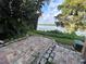 Brick patio leading to a serene lake view framed by lush greenery and mature trees at 4154 Versailles Dr # 4154D, Orlando, FL 32808