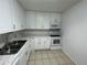 Functional kitchen featuring white cabinets, neutral countertops, and essential appliances at 4154 Versailles Dr # 4154D, Orlando, FL 32808